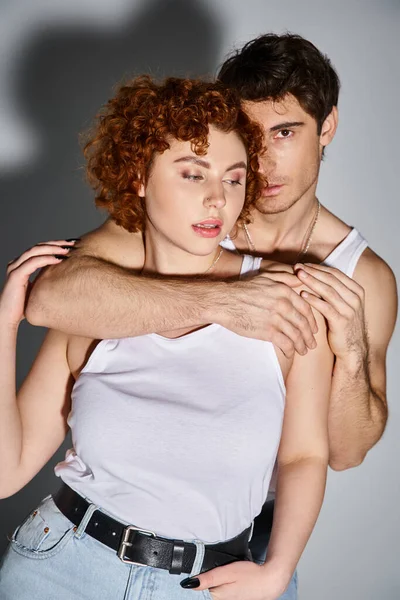 Schöner Mann umarmt liebevoll seine schöne verführerische Freundin und schaut in die Kamera, sexy Paar — Stockfoto