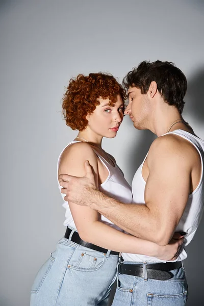 Good looking man hugging lovingly his beautiful girlfriend while she looking at camera, sexy couple — Stock Photo