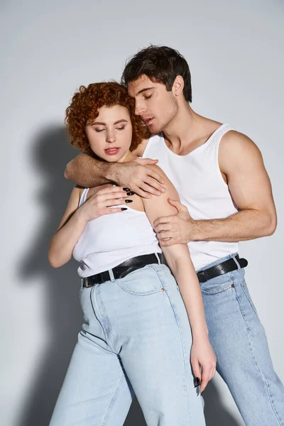 Atractivo amoroso hombre y mujer en atuendos casuales abrazos antes de besar apasionadamente, sexy pareja - foto de stock