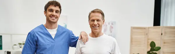 Joyous attractive doctor and his mature jolly patient posing together and smiling at camera, banner — Stock Photo