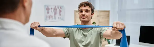 Beau médecin mature vérifiant les genoux de son patient à l'hôpital, concept de réadaptation — Photo de stock