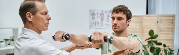 Good looking mature doctor checking up knees of his patient in hospital, rehabilitation concept — Stock Photo