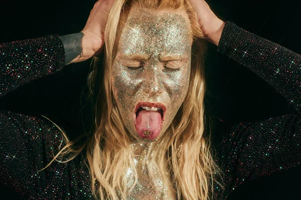 Portrait of provocative woman with glitter on face and body rolling eyes on black background — Stock Photo