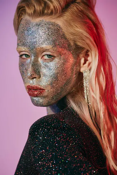 Portrait of striking blonde woman with glitter makeup and shiny dress posing on pink backdrop — Stock Photo