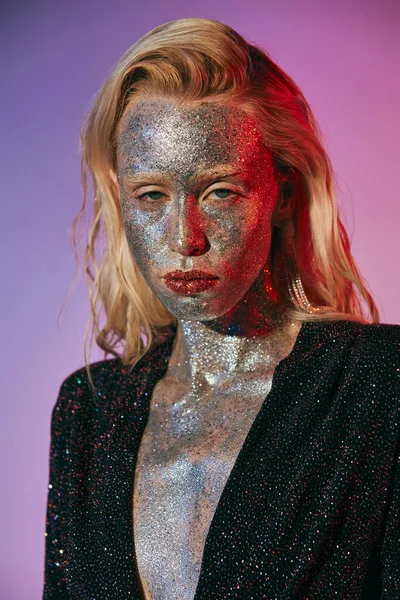 Portrait of pretty and blonde woman with glitter makeup and shiny dress posing on pink backdrop — Stock Photo