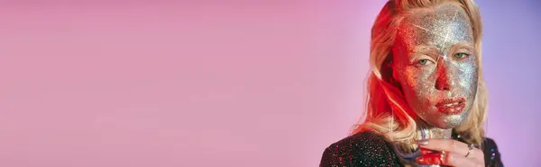 Banner einer hübschen jungen Frau mit Glitzerschminke und grünen Augen, die vor rosa Hintergrund in die Kamera blickt — Stockfoto