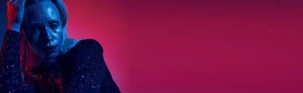 Banner einer hübschen jungen Frau mit Glitzer im Gesicht und glänzendem Outfit posiert auf neonfarbenem Hintergrund — Stockfoto