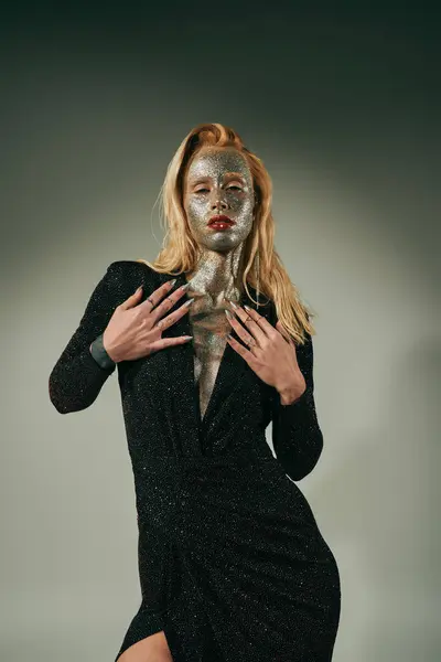 Blonde woman in shiny party dress with glitter all over her body and face posing on grey backdrop — Stock Photo