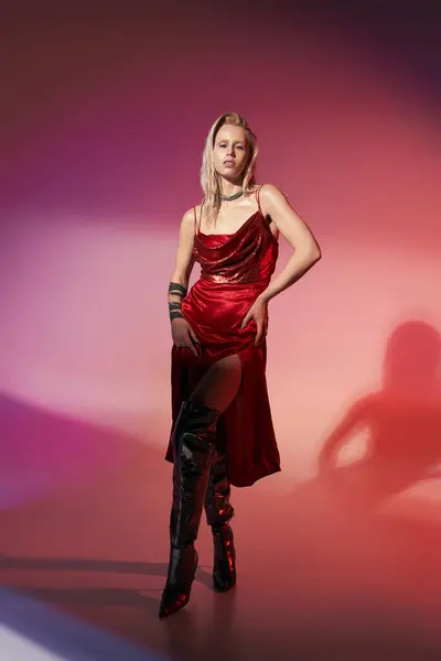 Femme sexy à la mode avec tatouage en robe élégante rouge posant alléchamment et regardant la caméra — Photo de stock