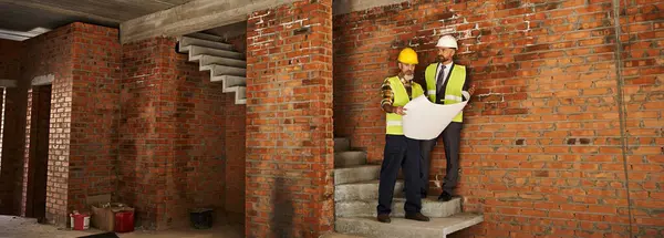 Devoted bearded cottage builder and architect working on construction site with blueprint, banner — Stock Photo