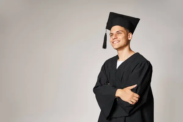 Portrait d'un étudiant attrayant en robe d'études supérieures et casquette souriant et impatient — Photo de stock