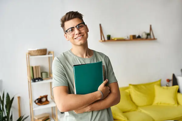 Studente carismatico con capelli castani e occhiali da vista in salotto tenendo note con le mani — Foto stock