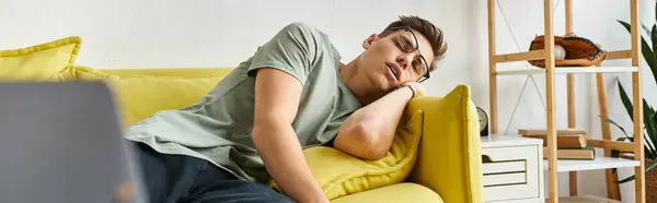 Banner of young man with brown hair and vision glasses sleeping on yellow couch in living room — Stock Photo