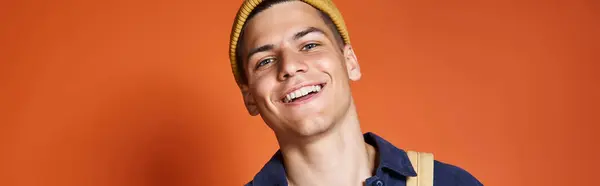 Banner of smiling student in yellow hat with backpack against terracotta background — Stock Photo