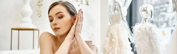 Eine junge brünette Braut, gekleidet in ein weißes Kleid, hält zart ihre Hände vor ihr Gesicht in einem Moment der stillen Besinnung. — Stockfoto