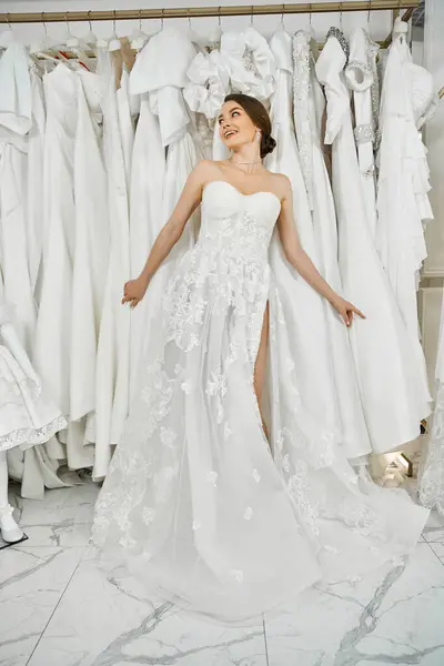 Eine junge, schöne Braut bewundert einen Kleiderständer in einem Hochzeitssalon und betrachtet ihr perfektes Kleid. — Stockfoto