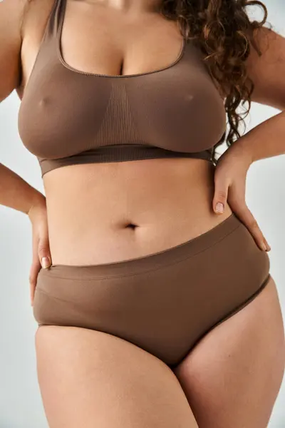 Cropped shot of body beautiful plus size young woman in underwear posing against grey background — Stock Photo