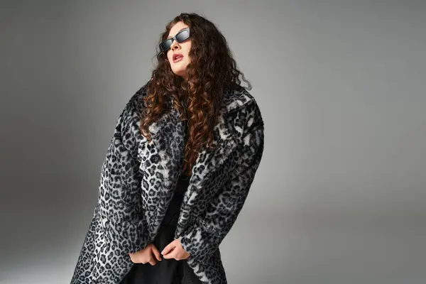 Alluring plus size woman in leopard fur coat and sunglasses leaning forward and looking to side — Stock Photo