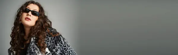 Bannière de femme élégante de taille plus en manteau de fourrure de léopard et lunettes de soleil penchées vers l'avant sur le gris — Photo de stock