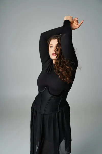 Beautiful curvy woman in black stylish outfit putting arms to up and looking to side — Stock Photo