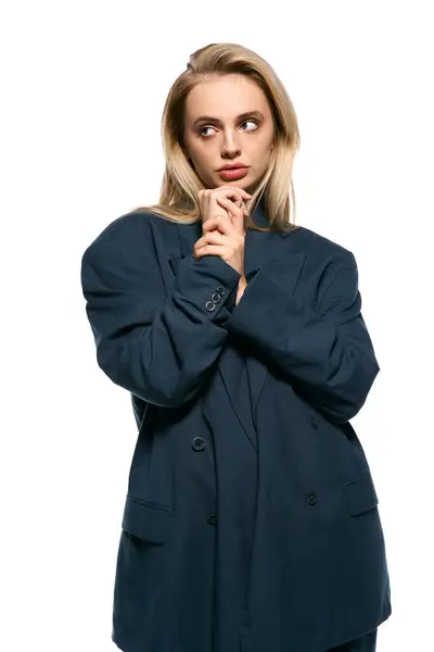 Mulher atraente com cabelo loiro em azul elegante blazer posando no fundo branco e olhando para longe — Fotografia de Stock