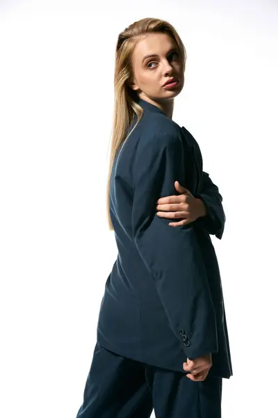 Attraktive Frau mit blonden Haaren im schicken blauen Blazer posiert auf weißem Hintergrund und schaut weg — Stockfoto