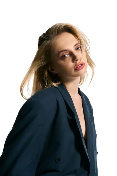 Appealing woman with blonde hair in stylish blazer posing on white backdrop and looking at camera — Stock Photo