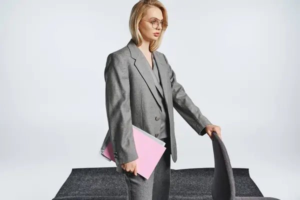 Debonair mulher de negócios na moda em terno cinza inteligente com óculos trabalhando com sua papelada — Fotografia de Stock