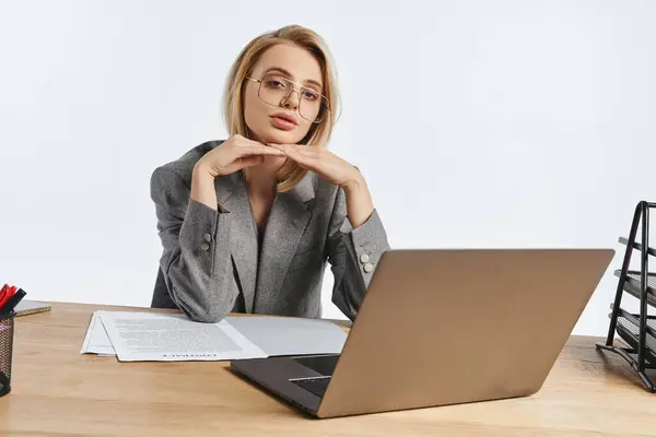 Raffinierte junge Geschäftsfrau im eleganten schicken Anzug blickt während der Arbeit mit Papieren in die Kamera — Stockfoto