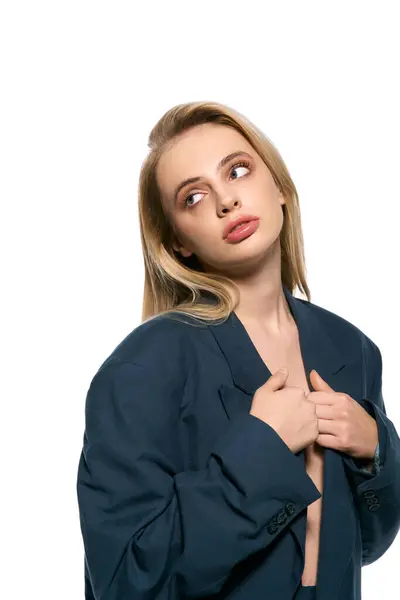 Beautiful sexy woman with blonde hair in black unbuttoned suit on white backdrop and looking away — Stock Photo