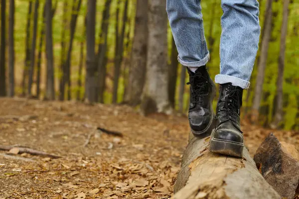 Cropped photo of female legs in hiking boots making a step on a wood in forest scenery — Stock Photo