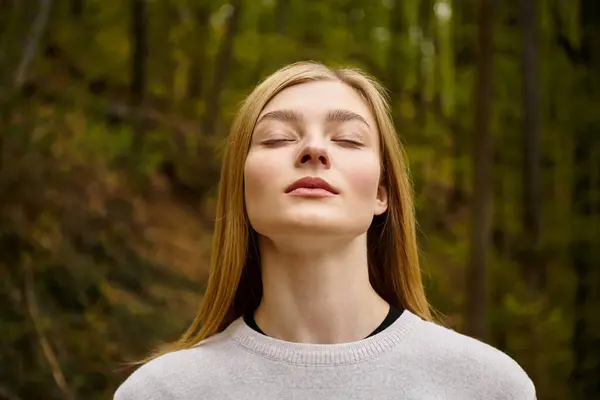 Femme blonde détendue respirant de l'air frais en forêt en randonnée en solo, portrait fermé — Photo de stock