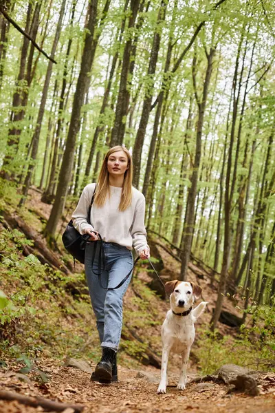 Cheerful woman walking her pet dog out while having backpacking trip with companion — Stock Photo