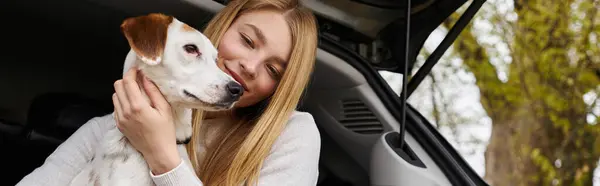 Menina feliz interagindo com seu animal de estimação olhando para o cão em caminhadas descanso parada na parte de trás do carro, banner — Fotografia de Stock