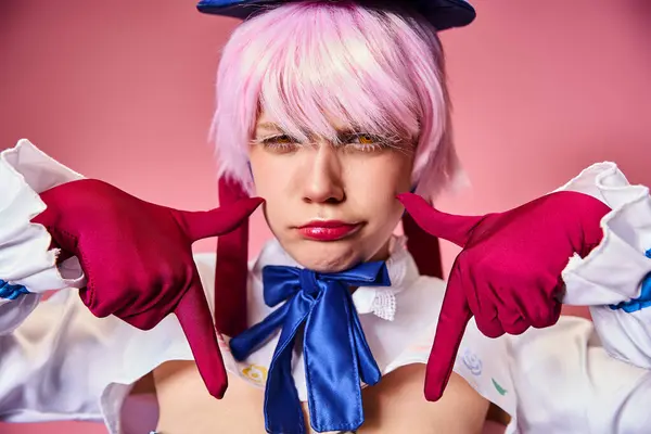 Good looking sexy woman with red gloves and blue hat showing crying gesture on pink backdrop — Stock Photo
