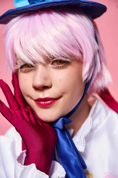 Glamorous sexy female cosplayer in blue hat and vibrant attire looking at camera on pink backdrop — Stock Photo