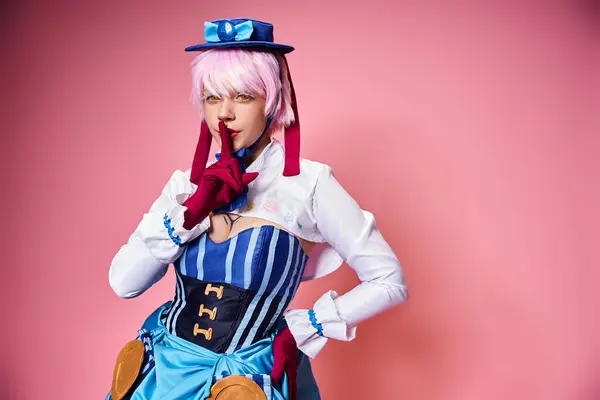 Gut aussehende schicke Frau Cosplay Anime-Charakter und zeigt Schweigegegeste auf rosa Hintergrund — Stockfoto