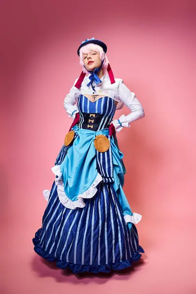 Appealing female cosplayer in blue stylish hat looking at camera posing with her arms on hips — Stock Photo