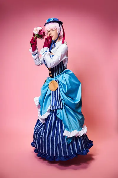 Attractive cute female cosplayer in vibrant costume holding pink flowers and looking at camera — Foto stock