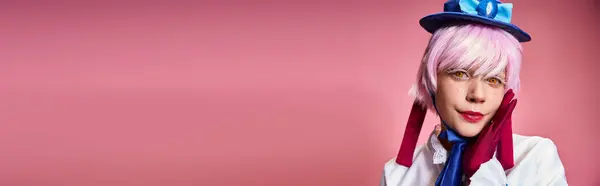 Ansprechender schicker Cosplayer mit blauem Hut und lebendigem Kleid, der auf rosa Hintergrund in die Kamera blickt, Banner — Stockfoto