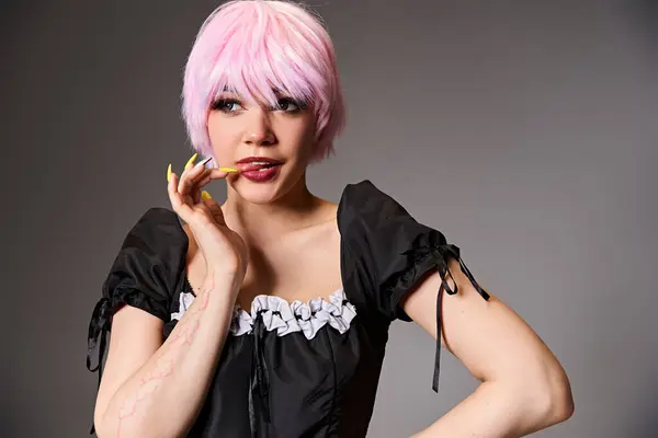 Привлекательная женщина, играющая сексуальную аниме-героиню с розовыми волосами и отводящая взгляд на заднем плане — стоковое фото