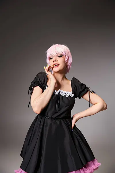 Приваблива шикарна жінка в чорній сукні з рожевим волоссям, що займається аніме персонажем і дивиться на камеру — Stock Photo