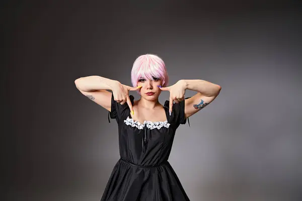 Gut aussehende Cosplayerin in schwarzem sexy Kleid mit weinenden Gesten und Blick in die Kamera — Stockfoto