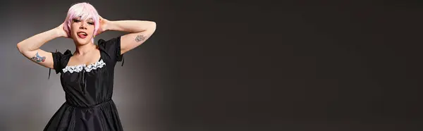Alegre cosplayer em traje de empregada com cabelo rosa colando a língua e olhando para a câmera, banner — Fotografia de Stock