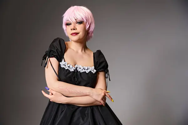 Ziemlich verführerisch Cosplayer in sexy Dienstmädchenkostüm mit rosa Haaren Blick in die Kamera auf grauem Hintergrund — Stockfoto