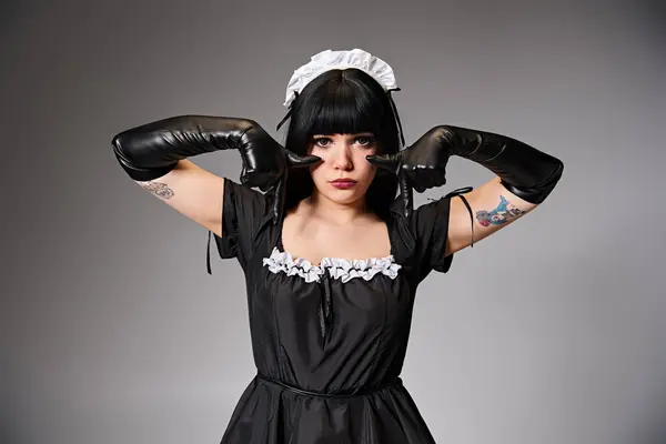 Seductora cosplayer femenino en traje de criada sexy mostrando gesto de llanto y mirando a la cámara - foto de stock