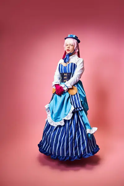Appealing woman cosplaying anime character with blue hat and red gloves and looking at camera — Stock Photo