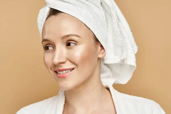 Una donna con un asciugamano avvolto intorno alla testa, che incarna grazia e bellezza naturale in un momento sereno. — Foto stock
