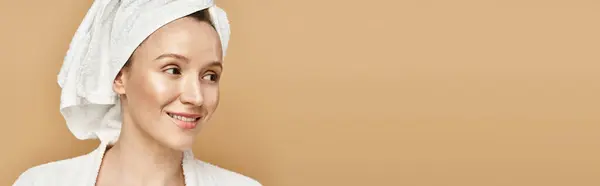 A beautiful woman with natural beauty and grace, confidently poses with a towel wrapped around her head. — Stock Photo