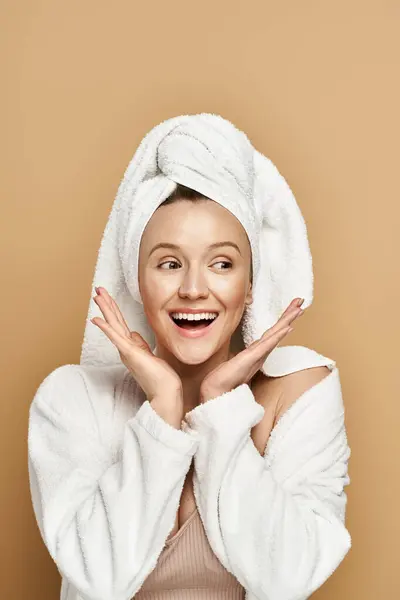 Uma mulher deslumbrante, irradiando beleza natural, usa uma toalha na cabeça em uma pose real. — Fotografia de Stock
